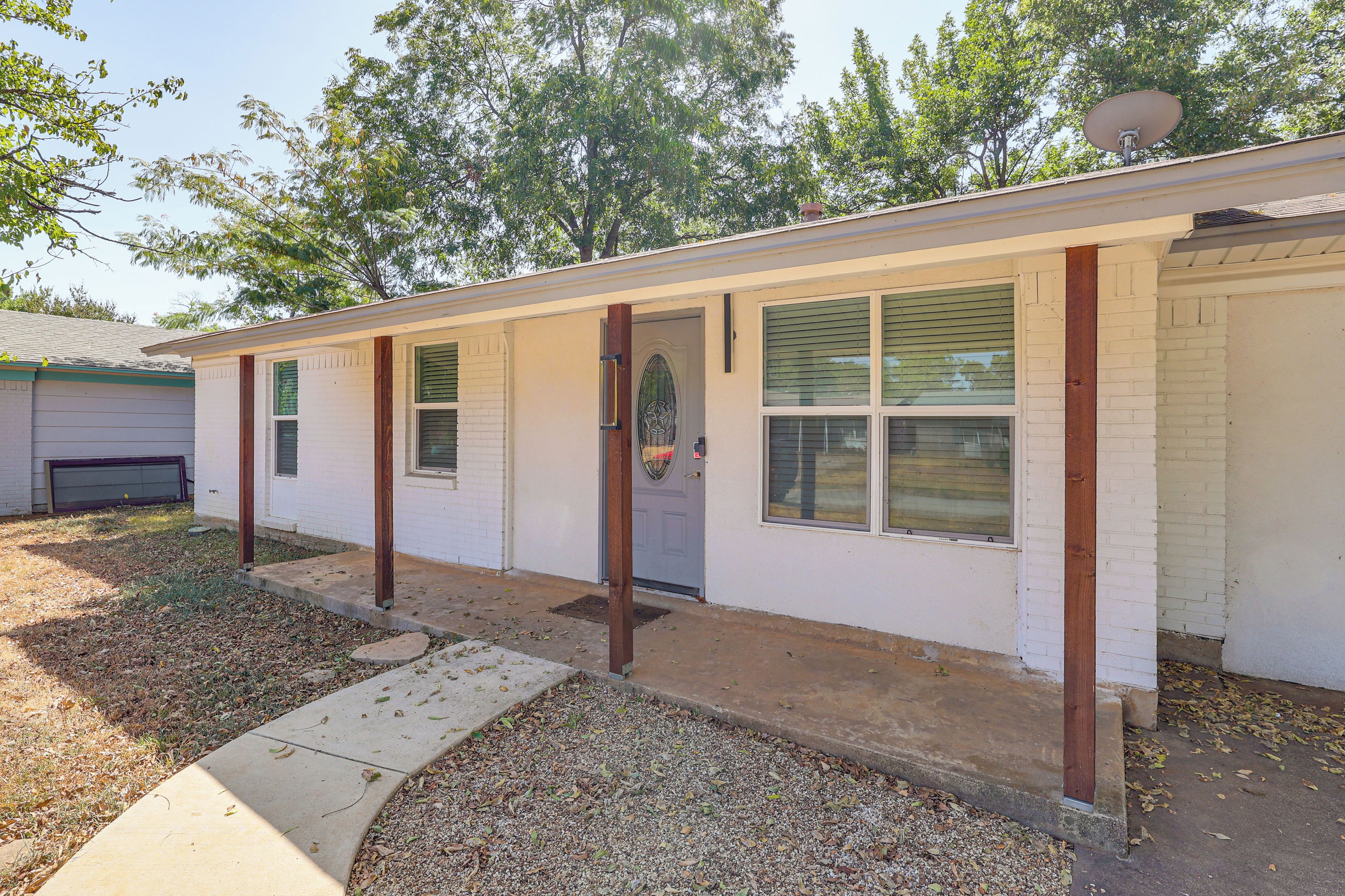 A single-story building with a front door, windows, and a satellite dish.