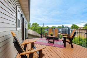 A wooden deck with outdoor furniture, a small table, and a rug. - Pet-friendly, Walkable Spearfish Townhome w/ Yard (Spearfish)