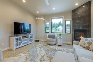A living room with a flat-screen TV, a fireplace, and a large window.