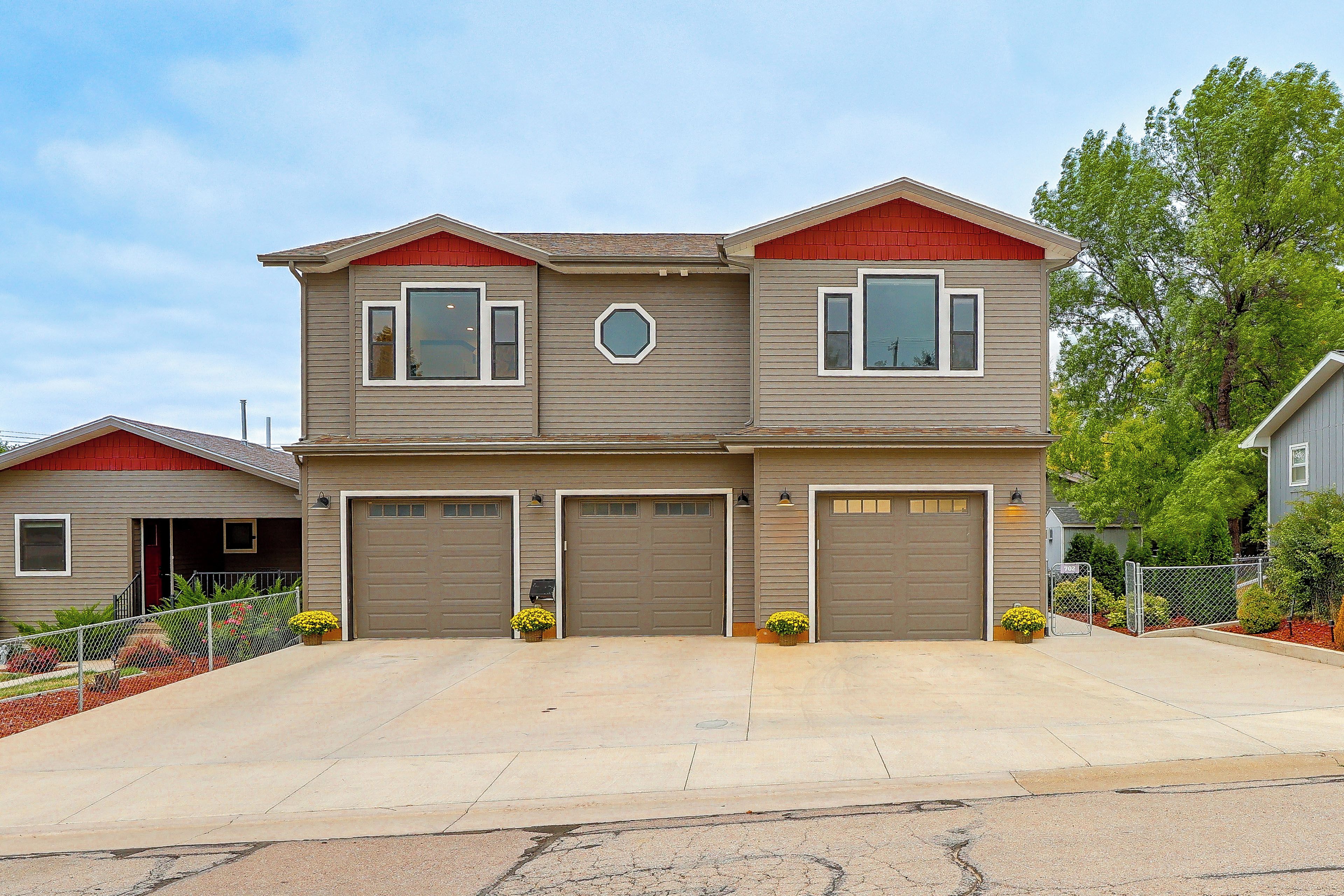 A two-story house with a garage, a front porch, and a fenced yard.