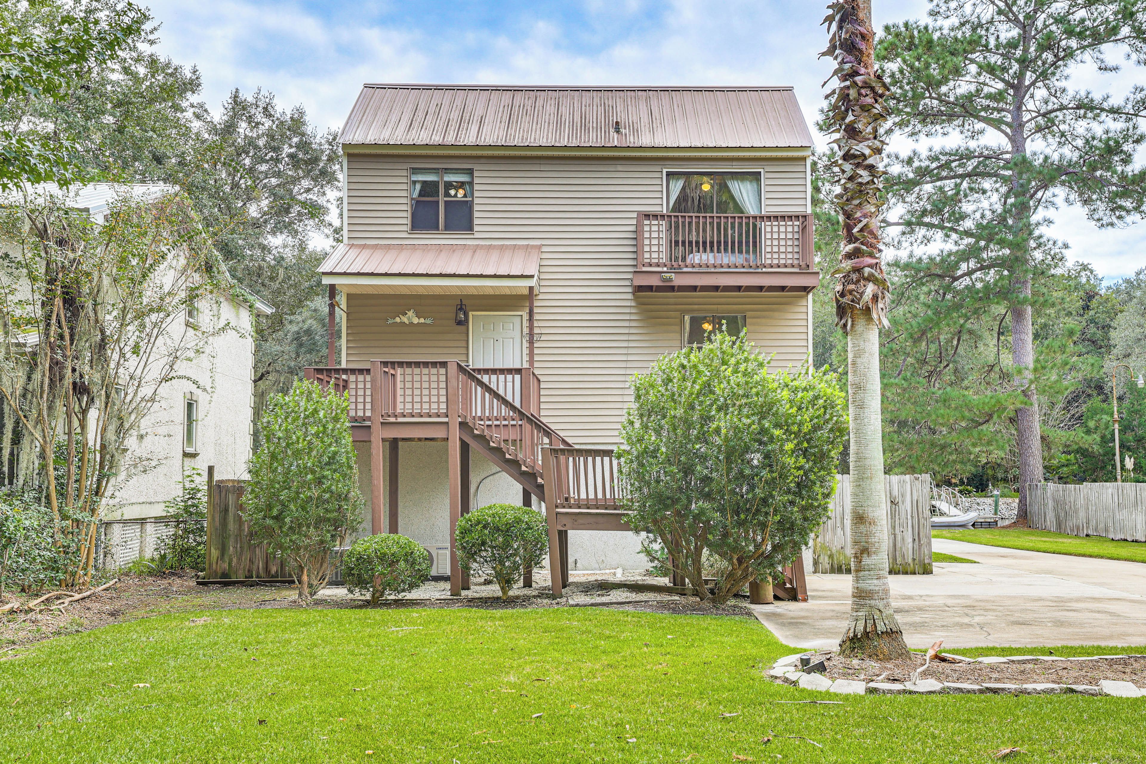 A two-story house with a front porch, a balcony on the second floor, and a small front yard.