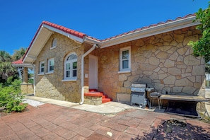 A stone house with a red roof, a front porch, and a barbecue grill. - Hidden Gem Near Ocean Center, Water Park & Theater (Daytona Beach)