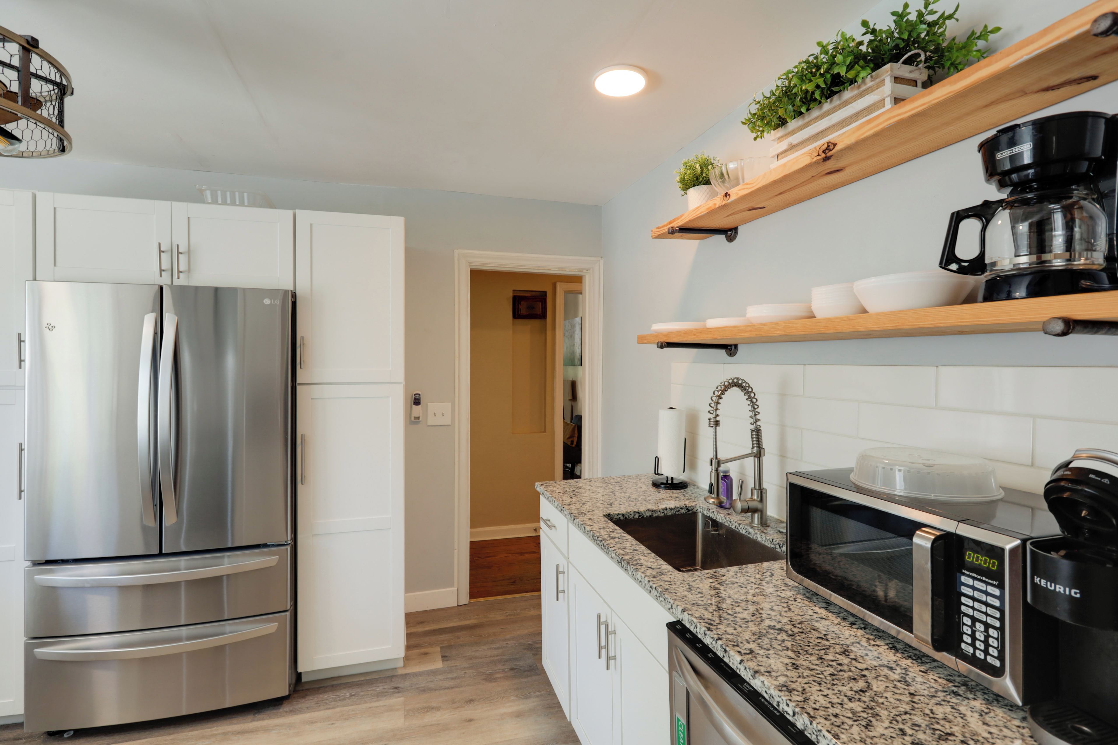 A modern kitchen with a stainless steel refrigerator, a microwave, and a coffee maker on the countertop.