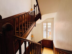 Eine Holztreppe mit Geländer, die zu einer Zwischenebene führt.