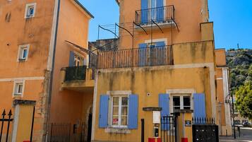Un immeuble de deux étages doté d’un balcon, d’une grille et d’un panneau indiquant qu’il est interdit de se garer sur le trottoir.