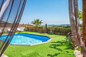 Ein Swimmingpool, umgeben von einem Holzzaun, mit Blick auf die Landschaft.