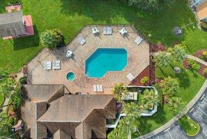An aerial view of a property with a swimming pool, lounge chairs, and a covered patio area. - Whimsical Wonders Sweetwater Club Near Disney (Kissimmee)