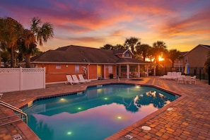 A swimming pool with lounge chairs and a building with a sloped roof. - Whimsical Wonders Sweetwater Club Near Disney (Kissimmee)
