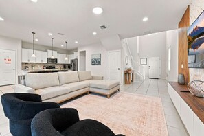 Een moderne woonkamer met een hoekbank, een salontafel en twee fauteuils.