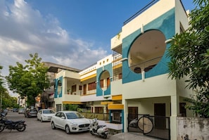 A multi-story residential building with balconies, parked cars, and scooters. - The Shyam Haven (UJJAIN)