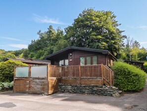 A cabin with a wooden deck, stone foundation, and a view of surrounding greenery. - 89 Ambleside (Windermere)