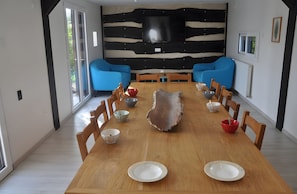 Comedor con una mesa de madera, sillas y una pared a rayas de cebra.