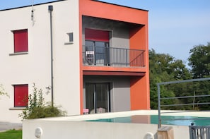 Un edificio moderno de dos pisos con una piscina al frente.