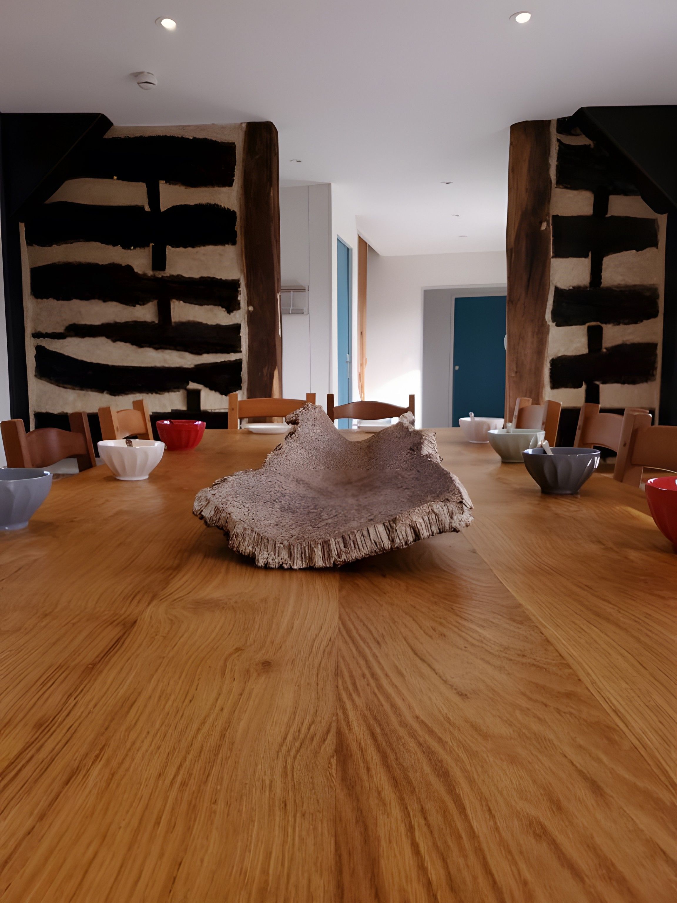 Zona pranzo con un tavolo rotondo in legno, sedie e un originale centrotavola decorativo.