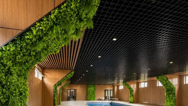 An indoor swimming pool with a tiled floor, surrounded by walls with vertical greenery. - Oxygen garden (Yangiabad)