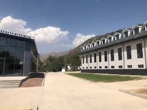 A modern building with a glass facade and a series of windows on the right side. - Oxygen garden (Yangiabad)