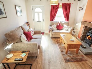 A cozy living room with a fireplace, two sofas, a coffee table, and a rug. - Seaglass Cottage (Hull)