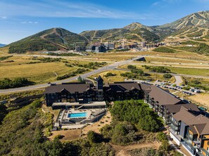 A hotel with a swimming pool, surrounded by a hilly landscape. - Studio in Deer Valley East Village with pool, hot tub, gym, and ski access. (Heber City)