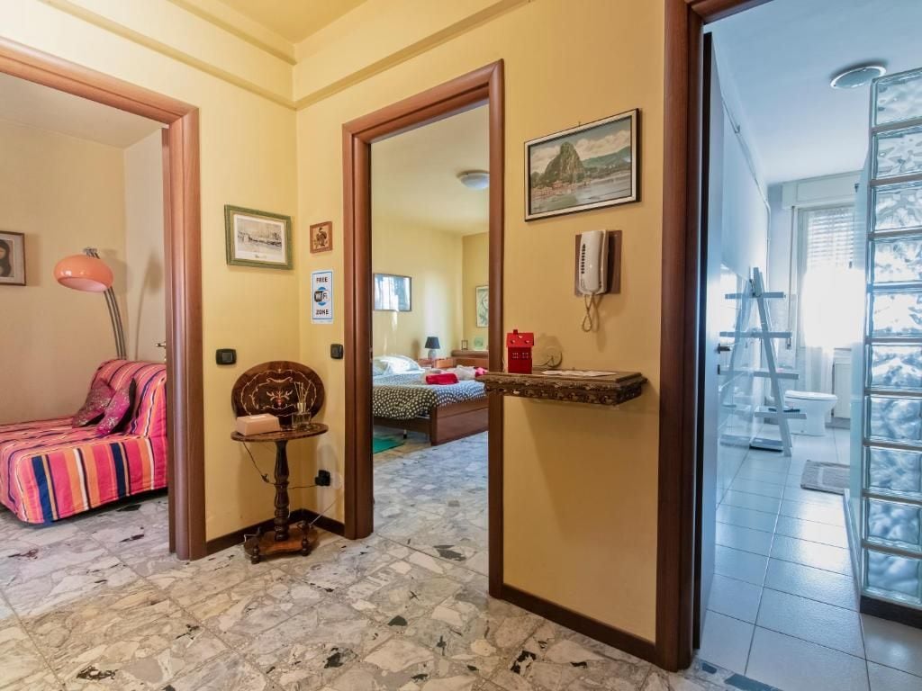 Habitación de hotel con cama, una mesita, una silla, un espejo y ventana con vistas.