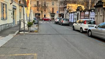 Una strada fiancheggiata da edifici e auto parcheggiate.