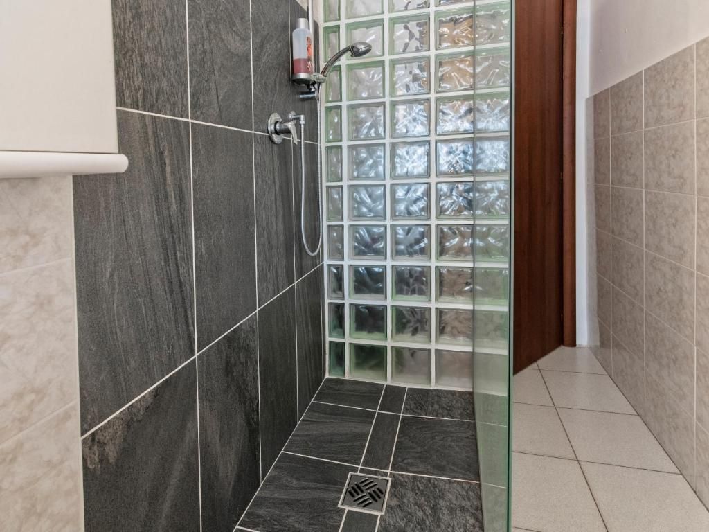 Ducha con puerta de vidrio, cabezal de ducha y secamanos.