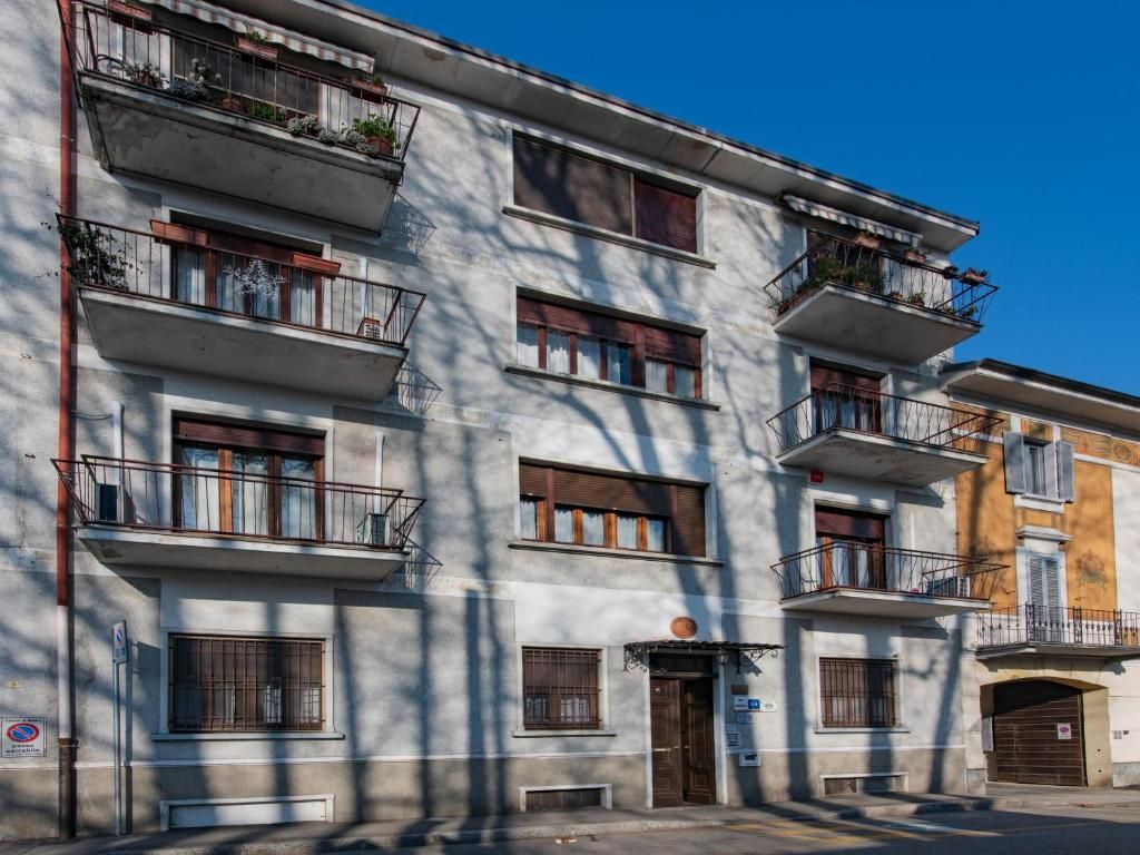Un edificio de varios pisos con balcones, ventanas y una puerta.