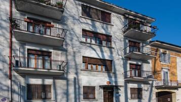 Un edificio de varios pisos con balcones, ventanas y una puerta.
