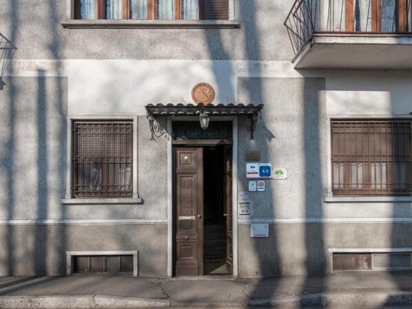 Fachada de edificio con puerta, ventanas y un reloj.