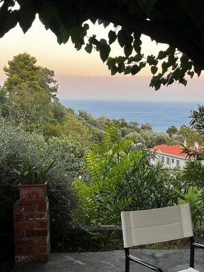 A bench overlooking a coastal landscape with dense foliage and a building with a red roof. - Country House 'The Arch House' with Sea View (Κύμη)