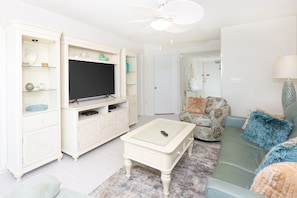 A living room with a television, a coffee table, and a sofa. - Phoenix Vi 6707 1 Bedroom Condo (Orange Beach)