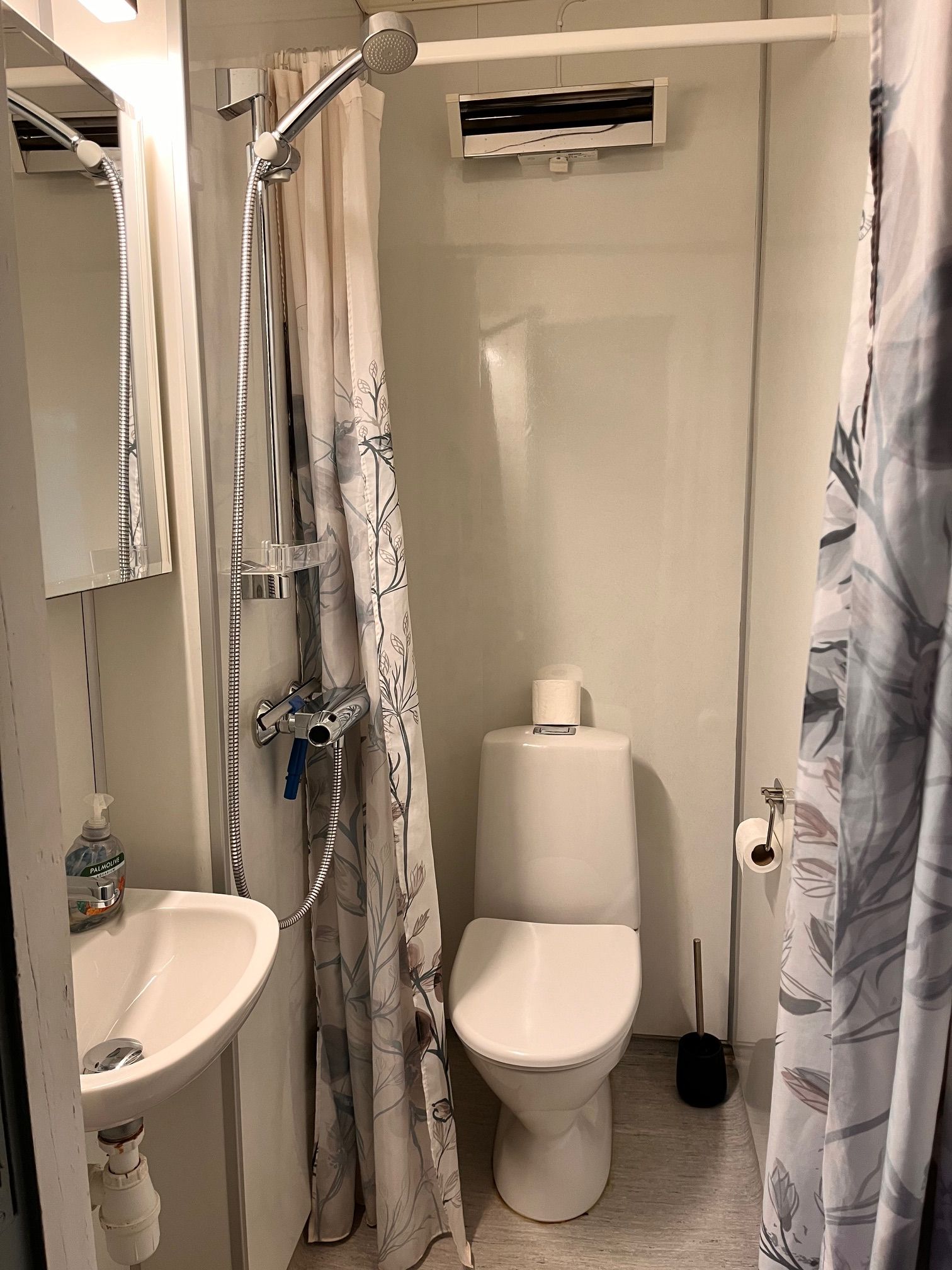 Une salle de bain équipée d’une douche, de toilettes, d’un lavabo et d’un porte-serviettes.