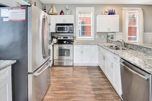 A kitchen with white cabinets, stainless steel appliances, a granite countertop, and a window with blinds. - SEAS THE DAY IS A PRIVATE 2BD COTTAGE WITH 3 COMMUNITY POOLS, PET FRIENDLY! (Port Saint Joe)