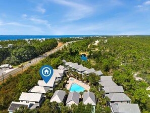 A resort with multiple buildings, a swimming pool, and a view of the ocean. - Pool Front Retreat! Barefoot Bliss is a 2BD cottage w/ 3 pools, 1 mile from Wind (Port St. Joe)