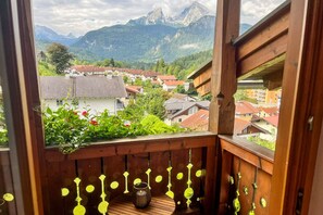A wooden balcony with a view of a mountain range and a village below. - Newly renovated "Königsblick" vacation rental with a view of the Watzmann (Berchtesgaden)