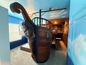 A ship's wheel mounted on a wall, a wooden door, and a window with blinds. - Heated Pool · Home Theater · Game Room · Sleeps 18 (Melbourne Beach)