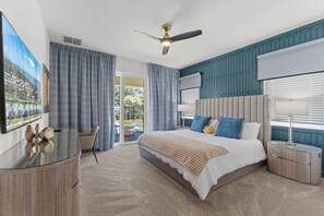 A bedroom with a bed, bedside tables, a ceiling fan, and a view through the window. - Heated Pool · Home Theater · Game Room · Sleeps 18 (Melbourne Beach)