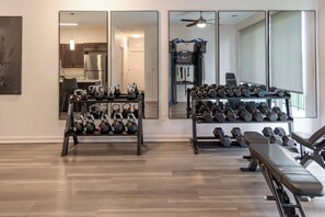 A home gym with kettlebells, dumbbells, and a bench. - Landing Amazing 1bd, Gym (Council Bluffs)