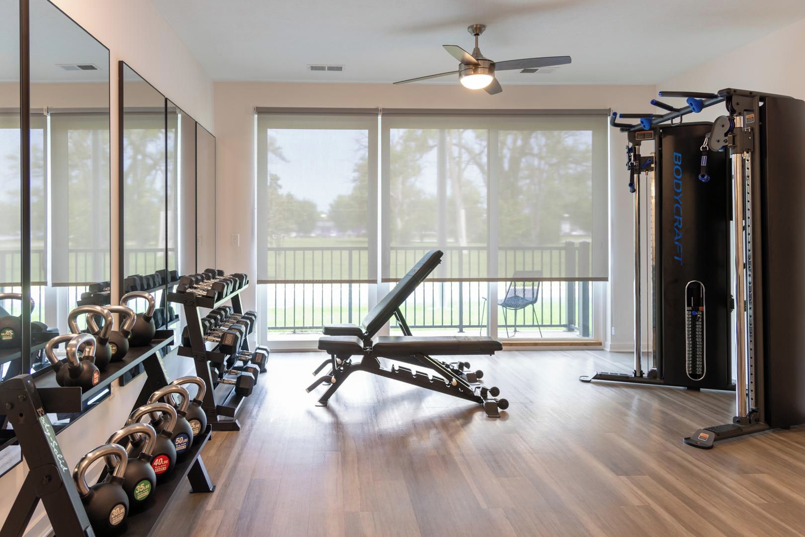 A home gym with exercise equipment, a bench, and a large mirror.