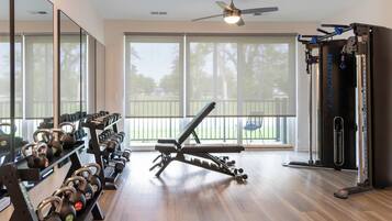 A home gym with exercise equipment, a bench, and a large mirror.