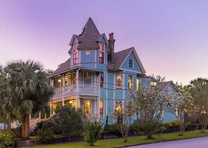 A large, multi-story house with a prominent tower, multiple balconies, and a well-maintained garden. - The General - Historic Pensacola Apt with Pool & Spa (Pensacola)