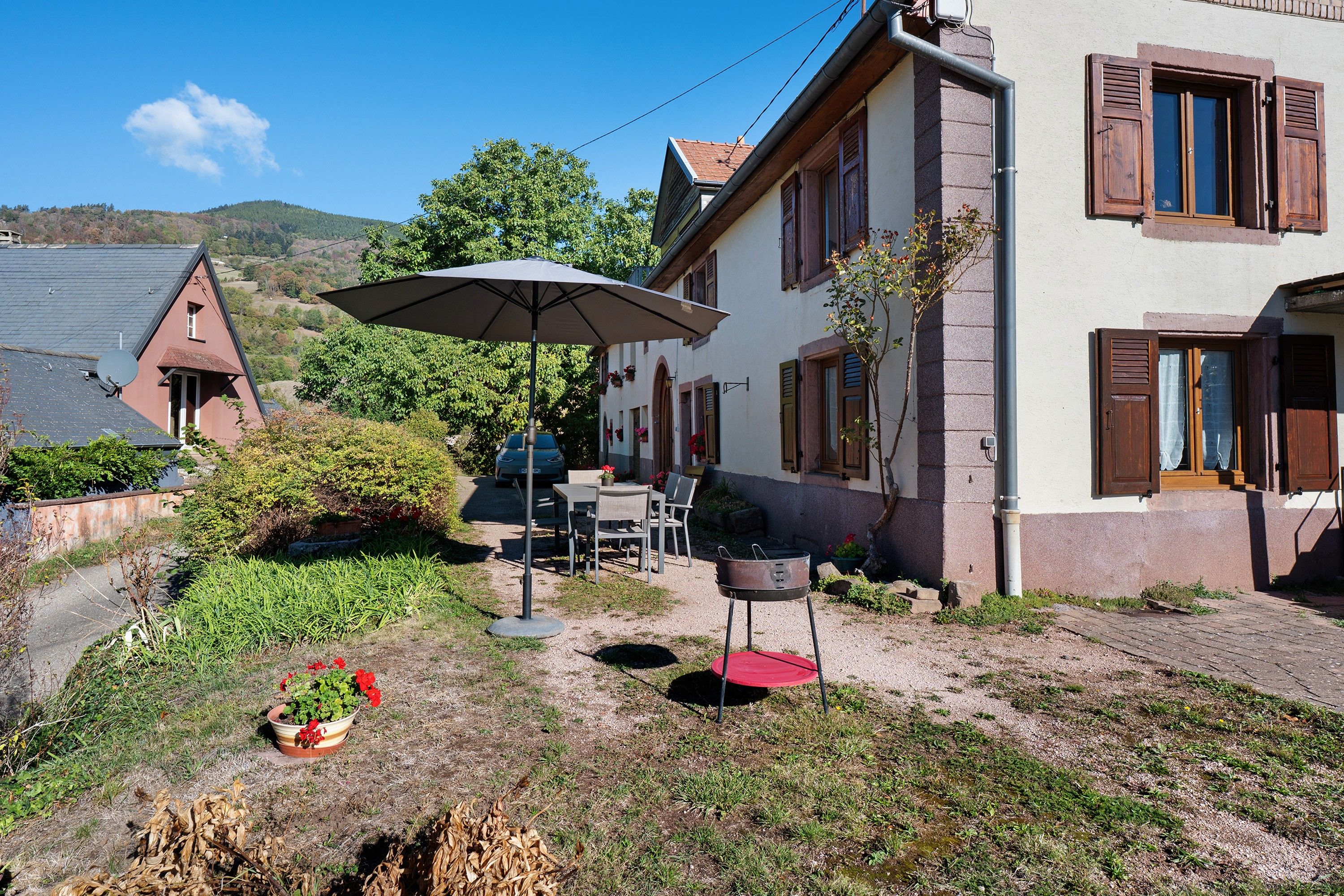 Une propriété résidentielle dotée d’une terrasse, d’un espace salon extérieur, d’un barbecue et d’une antenne parabolique.