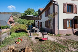 A residential property with a patio, outdoor seating, a barbecue grill, and a satellite dish.