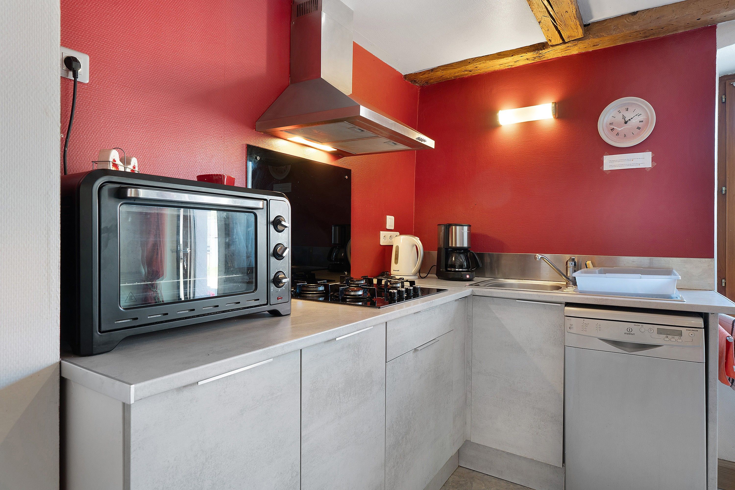 A compact kitchen with a built-in toaster, a coffee maker, and a dishwasher.