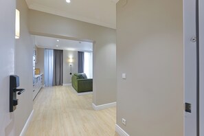 Un pasillo que conduce a una sala de estar con un sofá y una lámpara.