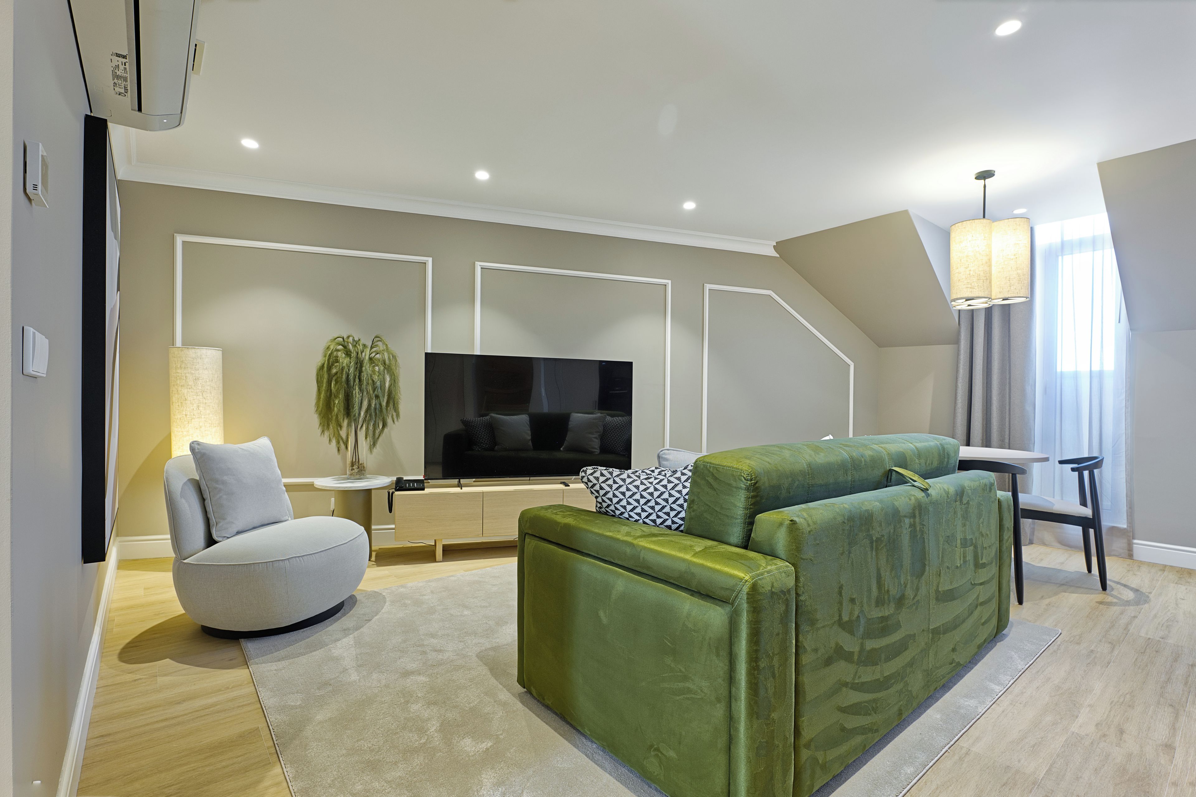 Una sala de estar moderna con un sofá modular, un televisor de pantalla plana y una mesita auxiliar.