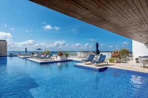 A rooftop infinity pool with lounge chairs and potted plants, overlooking a clear blue sky and ocean. - Mamitas Beach & 5 ta street | Pool & Ocean Views (Playa del Carmen)