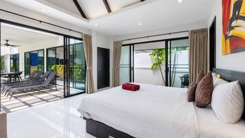 Un dormitorio moderno con una cama grande, un ventanal corredero que da a un balcón y vistas al exterior.