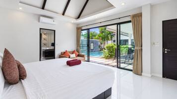 A modern bedroom with a large bed, a built-in air conditioning unit, a sliding glass door leading to a pool area, and a dark door.