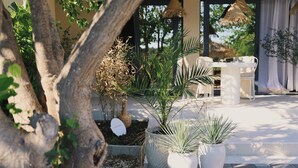A patio area with potted plants, a table, and chairs. - Casa Casolare by The Residence (Šibenik)