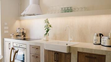 A modern kitchen with a central island, wooden cabinets, a built-in oven, and a range hood.